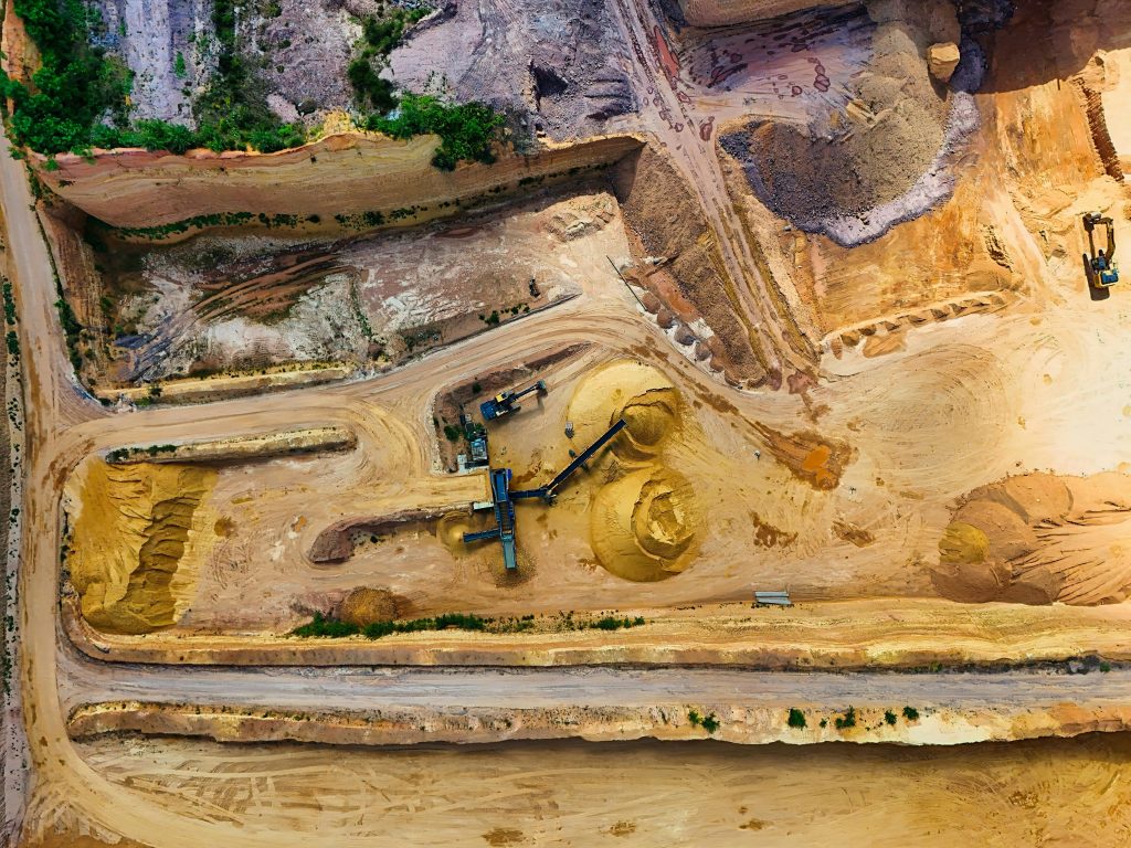 Aerial shot of a quarry with machinery extracting and processing materials.